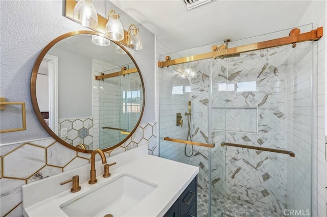 bathroom featuring visible vents, a shower stall, and vanity