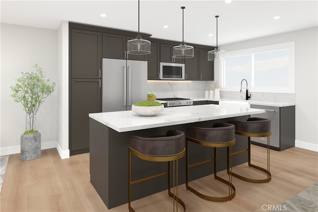 kitchen with stainless steel appliances, a center island, hanging light fixtures, and a sink