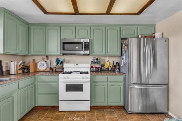 kitchen with stainless steel appliances, dark countertops, and green cabinetry