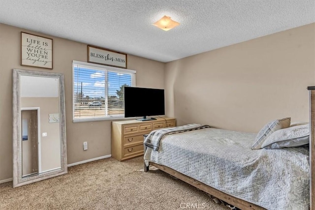 bedroom with light carpet, baseboards, and a textured ceiling