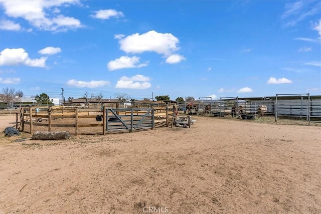 view of yard featuring an exterior structure, a rural view, and an enclosed area