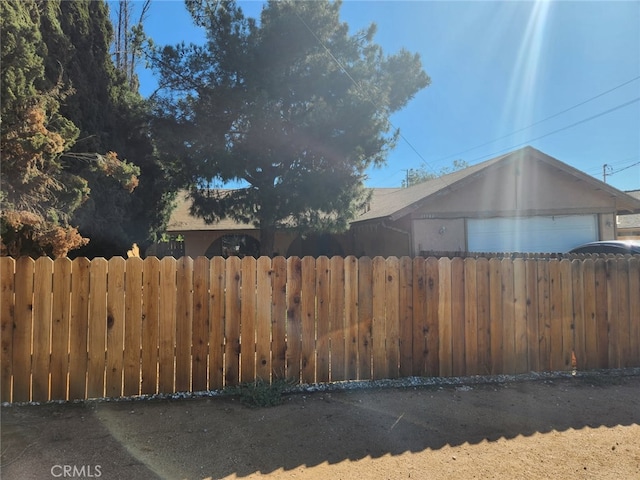 view of yard featuring a garage and fence