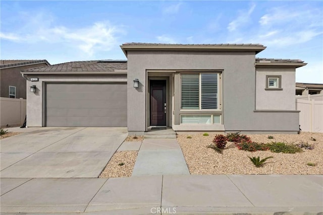 prairie-style home featuring fence, solar panels, stucco siding, and a garage