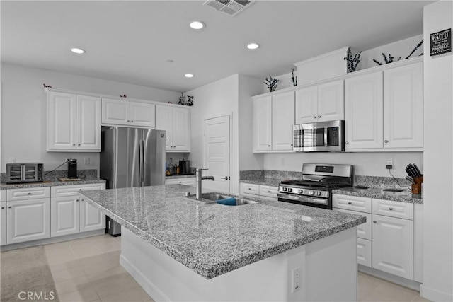 kitchen with a sink, visible vents, appliances with stainless steel finishes, and white cabinetry