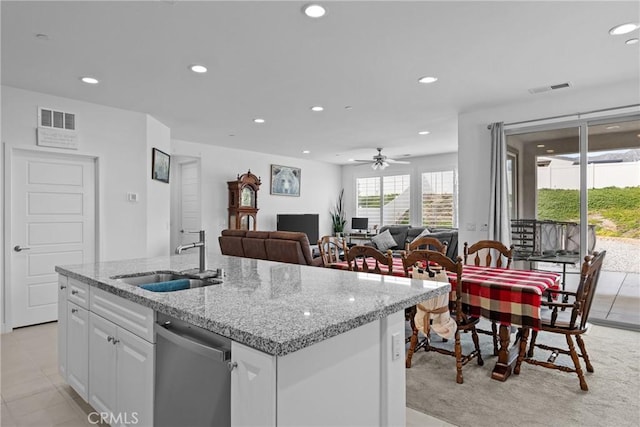 kitchen with dishwasher, a sink, white cabinetry, and visible vents