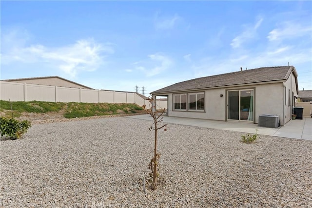rear view of property featuring stucco siding, fence, and a patio area