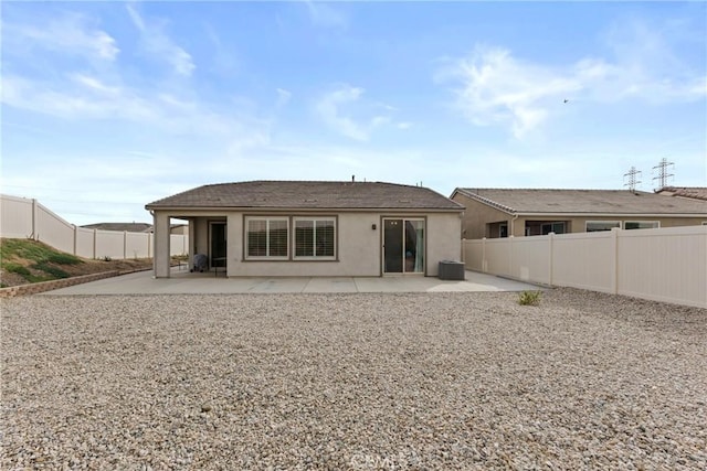 back of property with cooling unit, a fenced backyard, stucco siding, and a patio area