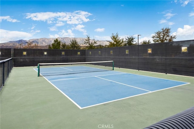 view of sport court featuring community basketball court, fence, and a mountain view