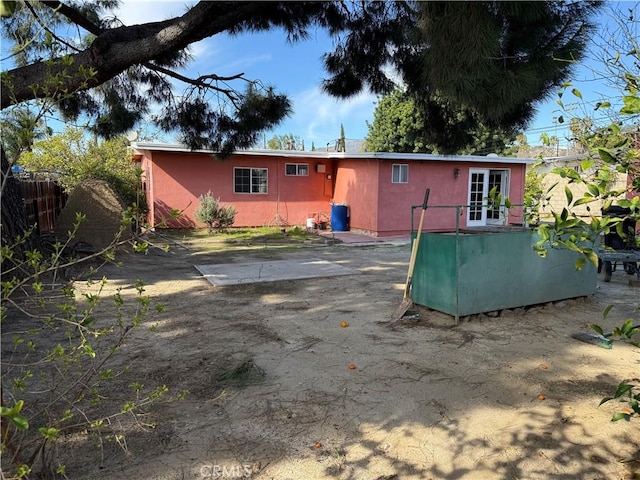 back of house with french doors and stucco siding