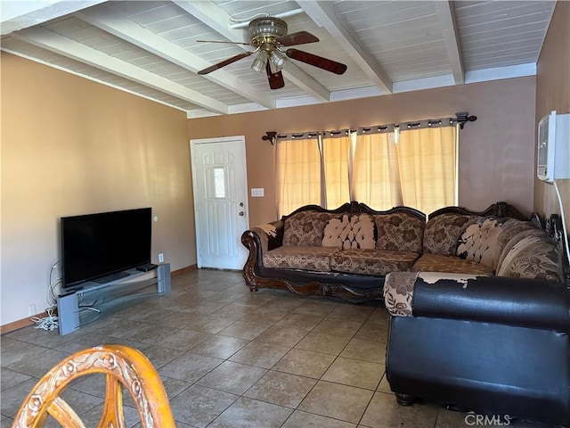 living room with a ceiling fan, beamed ceiling, baseboards, and tile patterned floors