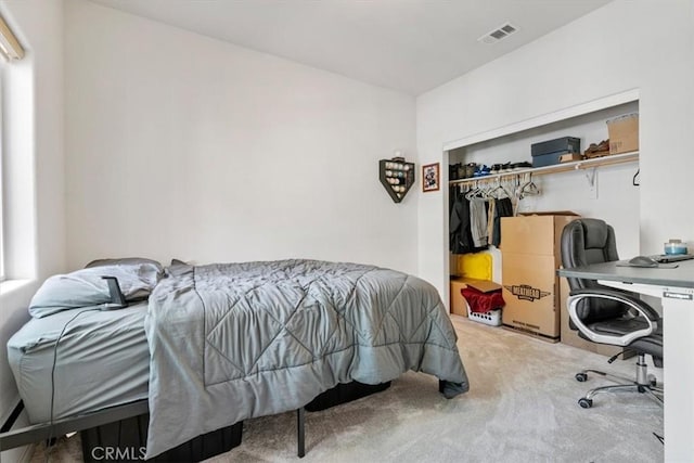 bedroom with a closet, visible vents, and carpet flooring