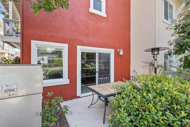 doorway to property with a patio area and stucco siding