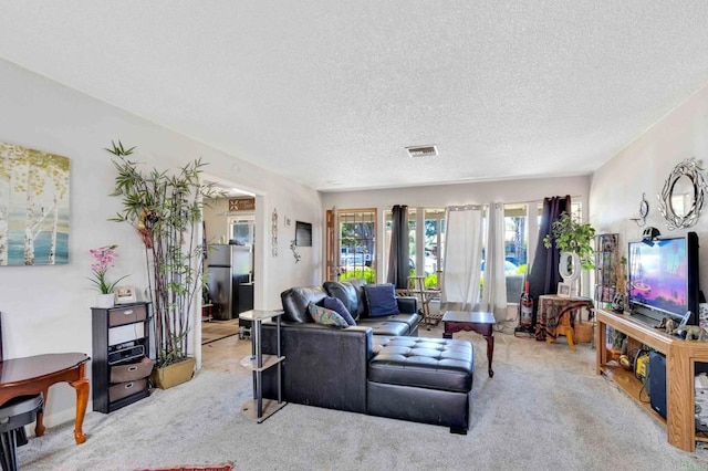 living area featuring visible vents, a textured ceiling, and light colored carpet