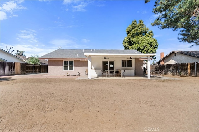 rear view of property featuring a patio, a fenced backyard, a ceiling fan, and stucco siding