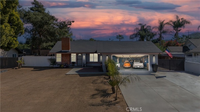 view of front of property with an attached garage, driveway, a chimney, and fence