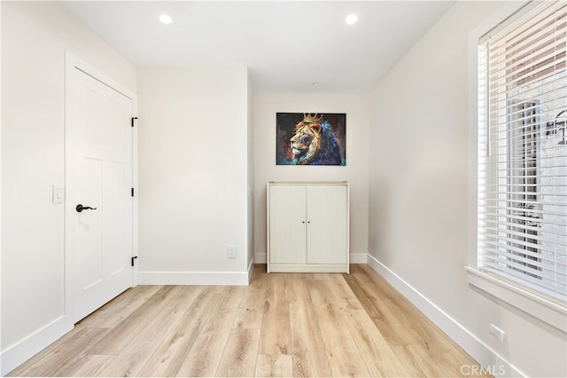 unfurnished bedroom with multiple windows, recessed lighting, light wood-style flooring, and baseboards