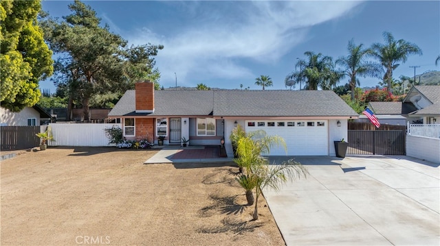 single story home featuring an attached garage, driveway, a chimney, and fence