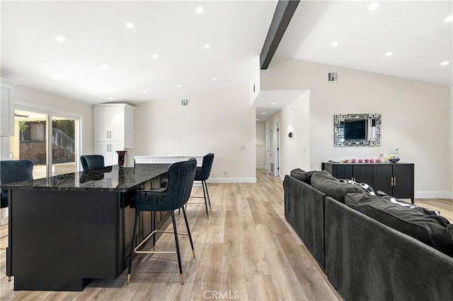 living room with vaulted ceiling with beams, light wood finished floors, recessed lighting, and baseboards