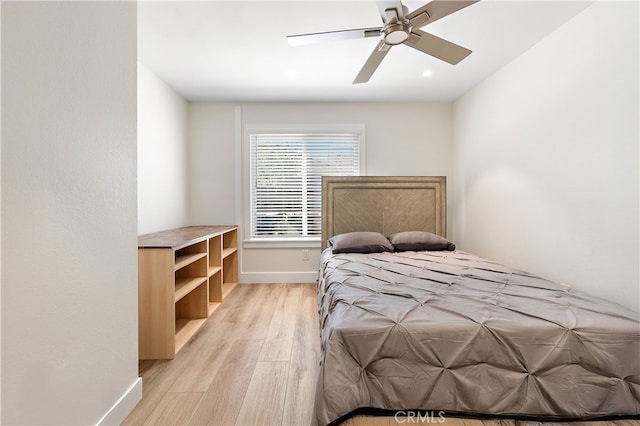 bedroom featuring ceiling fan, light wood finished floors, and baseboards