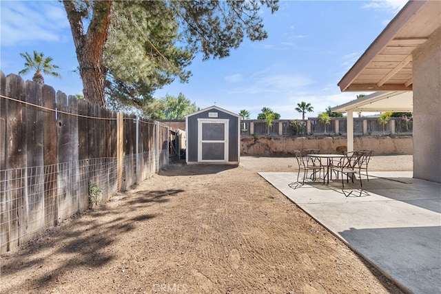 view of yard with an outbuilding, a fenced backyard, and a shed