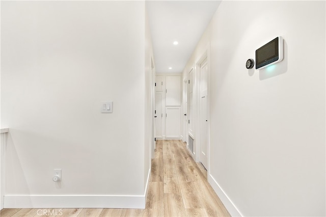 hall featuring recessed lighting, light wood-type flooring, and baseboards