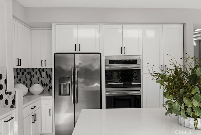 kitchen featuring white cabinets, stainless steel appliances, and light countertops