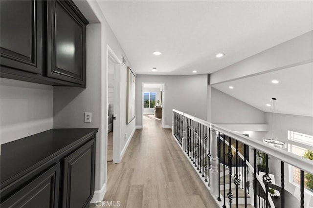 hall with baseboards, recessed lighting, plenty of natural light, and light wood-style floors