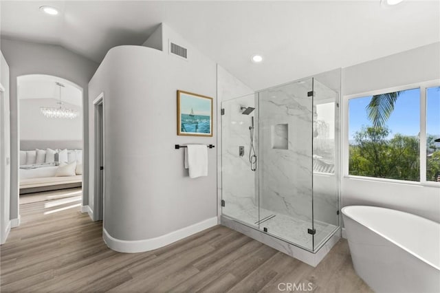 ensuite bathroom with lofted ceiling, wood finished floors, connected bathroom, and visible vents