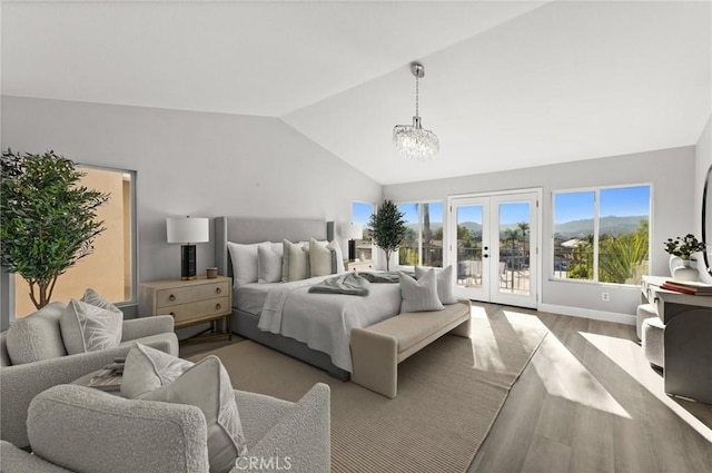 bedroom with lofted ceiling, wood finished floors, access to outside, french doors, and a chandelier