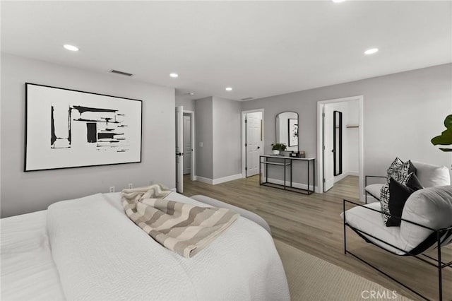 bedroom featuring baseboards, visible vents, wood finished floors, and recessed lighting