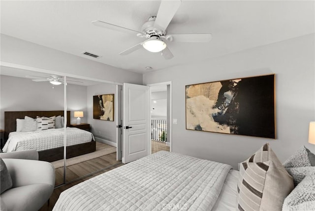 bedroom with visible vents, ceiling fan, baseboards, and wood finished floors