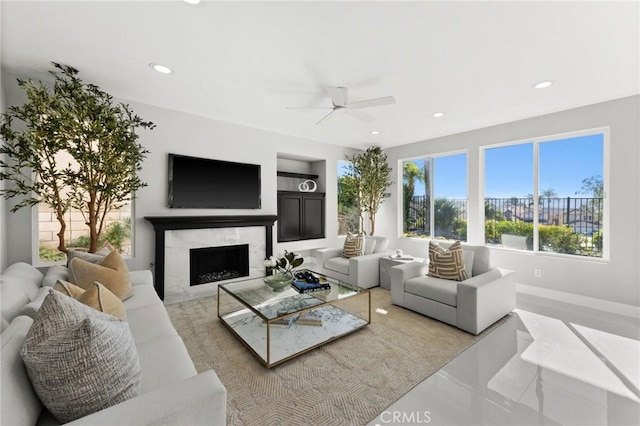 living room featuring ceiling fan, recessed lighting, a fireplace, and built in features