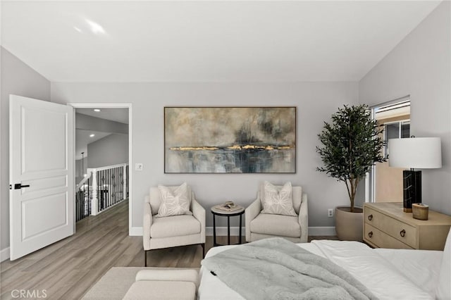 bedroom featuring light wood finished floors, baseboards, and vaulted ceiling