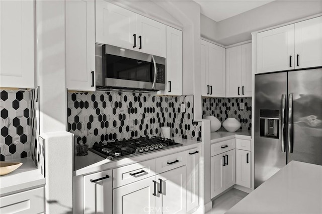 kitchen featuring appliances with stainless steel finishes, light countertops, white cabinetry, and tasteful backsplash