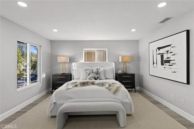 bedroom featuring baseboards, wood finished floors, visible vents, and recessed lighting