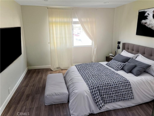 bedroom with wood finished floors and baseboards