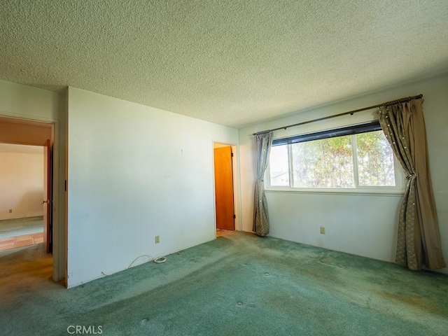 spare room with a textured ceiling and light colored carpet