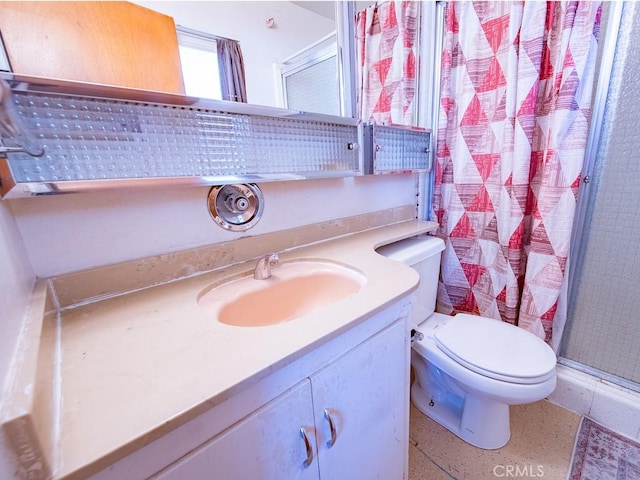 bathroom featuring toilet, a stall shower, and vanity