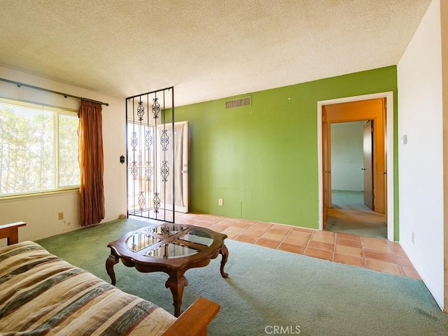 tiled living room with carpet, visible vents, and a textured ceiling