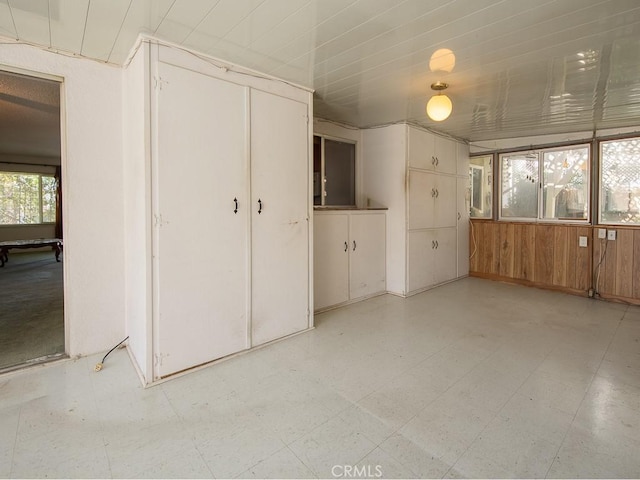 unfurnished bedroom with light floors and wood walls