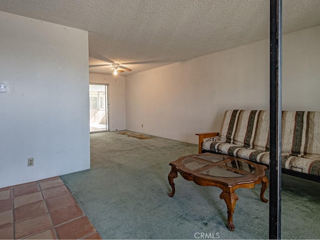 unfurnished room with carpet floors, a ceiling fan, a textured ceiling, and tile patterned floors