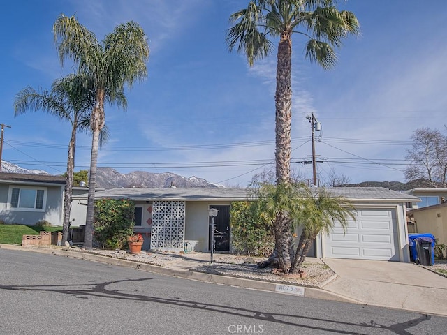 ranch-style house with a garage, concrete driveway, and stucco siding