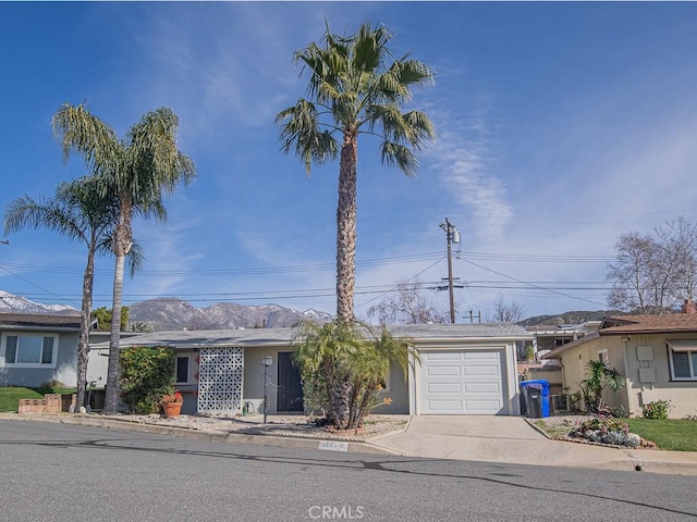 ranch-style house featuring an attached garage, concrete driveway, and stucco siding