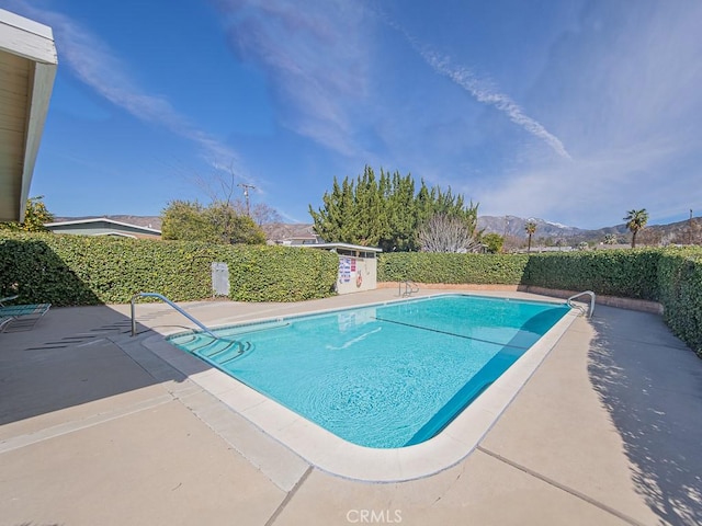 view of pool featuring a fenced in pool, a patio area, and a mountain view