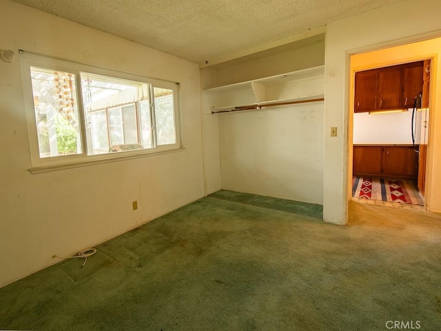 unfurnished bedroom featuring a closet, a textured ceiling, and carpet flooring