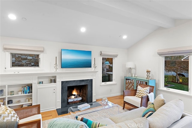 living room featuring lofted ceiling with beams, light wood-style floors, a premium fireplace, and recessed lighting