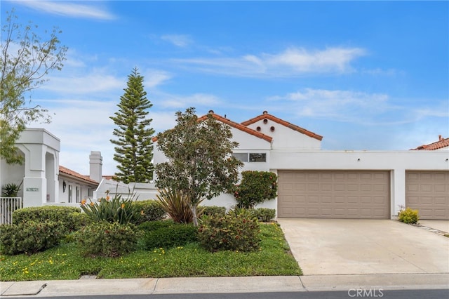 view of front of home with an attached garage, concrete driveway, and stucco siding