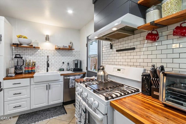 kitchen featuring white gas stove, a sink, wood counters, wall chimney exhaust hood, and open shelves