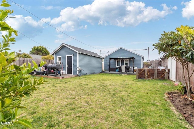 rear view of house featuring a fenced backyard, a patio, a lawn, and an outdoor structure