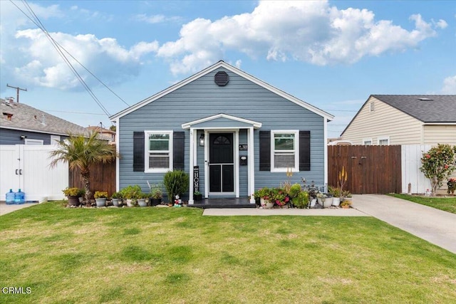 view of front of home featuring a gate, fence, and a front lawn